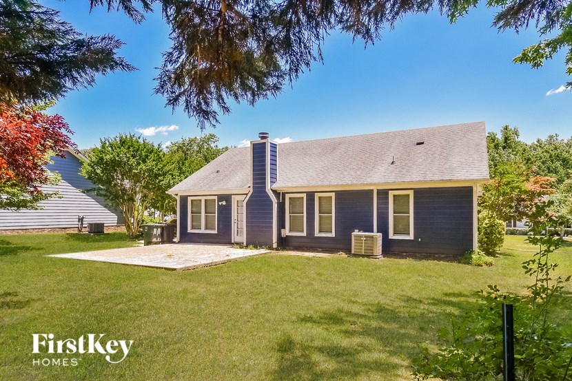 a blue house with a grassy yard and a white house