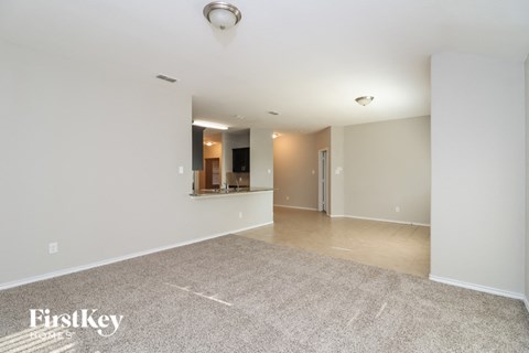 A spacious room with a carpeted floor and a FirstKey logo on the bottom left.