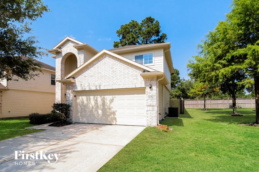 a white brick house with a white garage door and a lawn