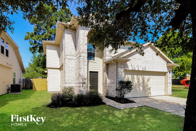 a white brick house with a garage and a lawn