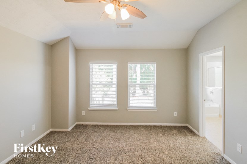 a empty room with two windows and a ceiling fan
