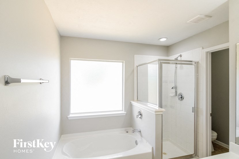 a bathroom with a tub and a shower and a window