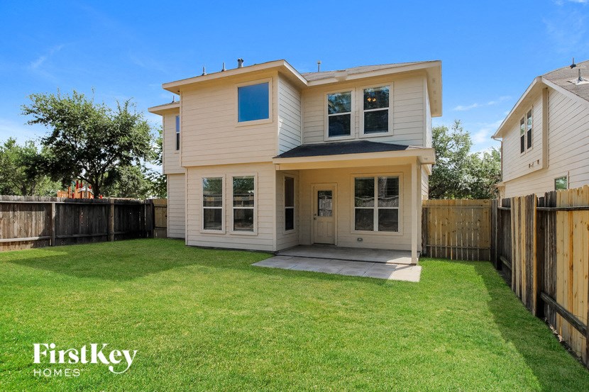 a white house with a yard and a wooden fence
