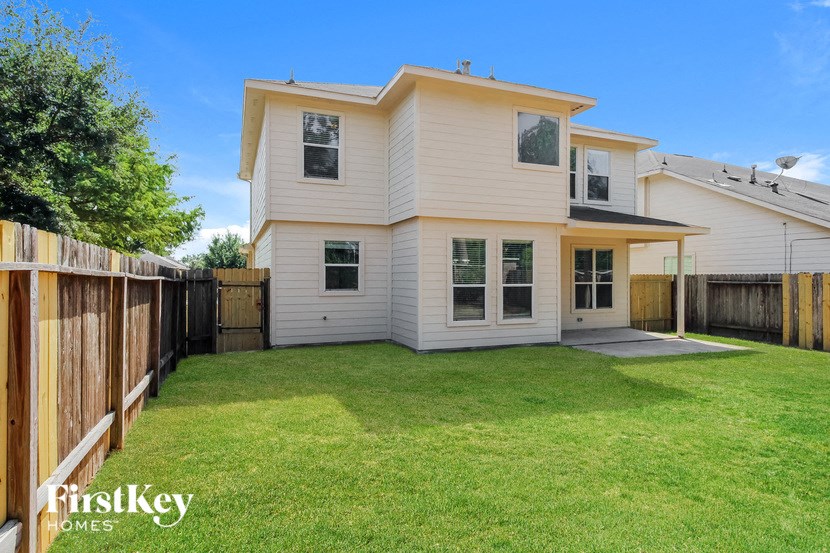 a white house with a yard and a wooden fence