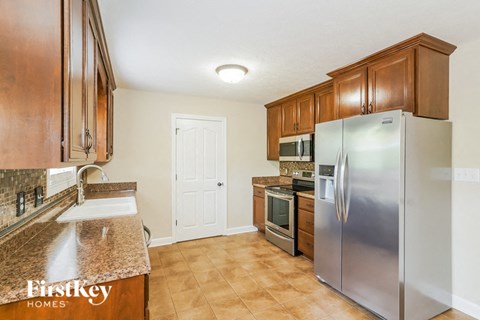 A kitchen with wooden cabinets and a granite counter top.