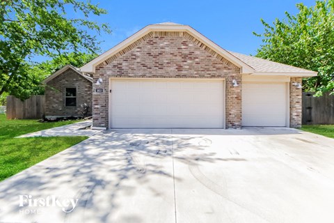 a white garage door on a brick house with a white driveway