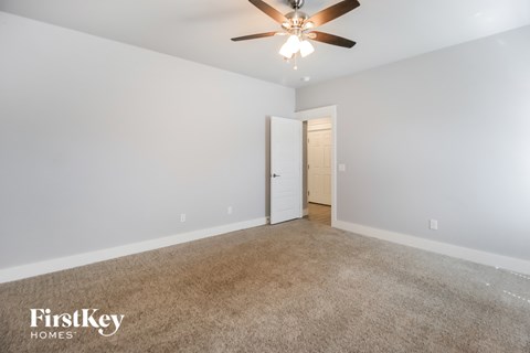a living room with a ceiling fan and a carpeted floor