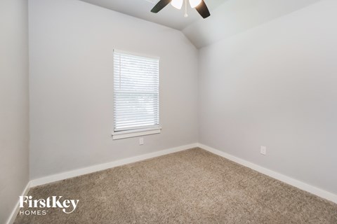 a bedroom with a carpeted floor and a window