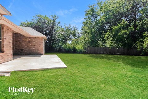 a backyard with a grass lawn and a house