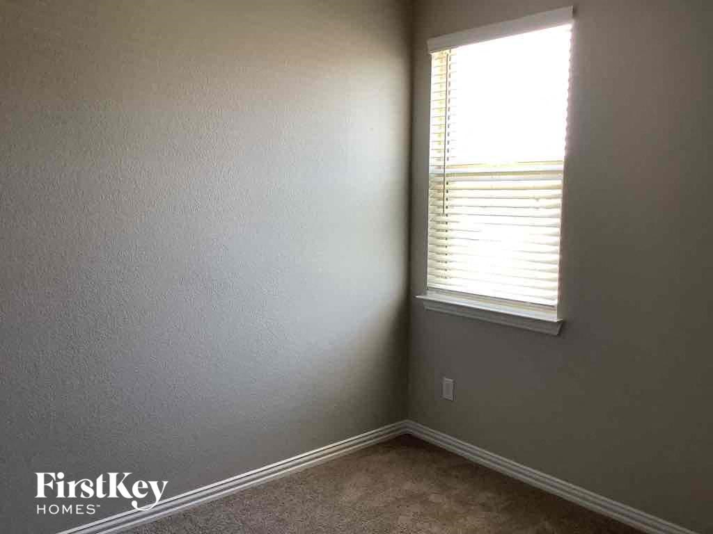 an empty room with a window and gray walls
