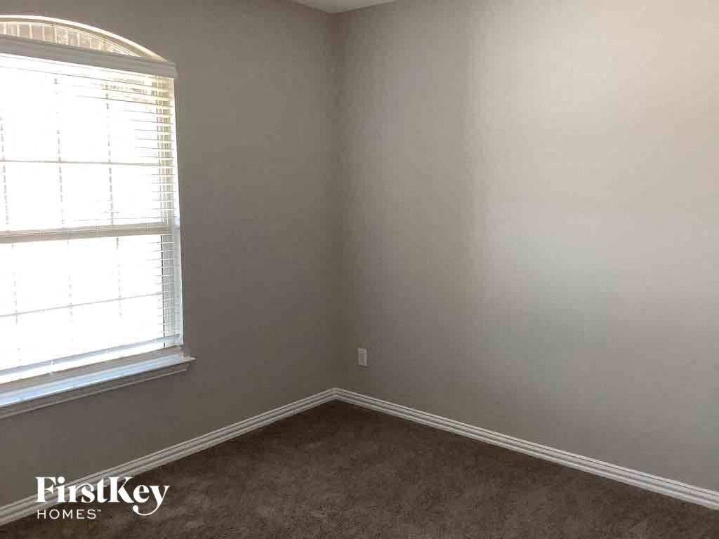 an empty room with a window and a carpet