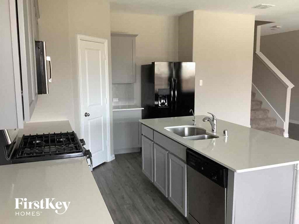 a kitchen with a sink and a stove and a refrigerator