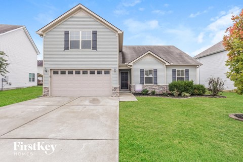 a white house with a driveway and a garage door