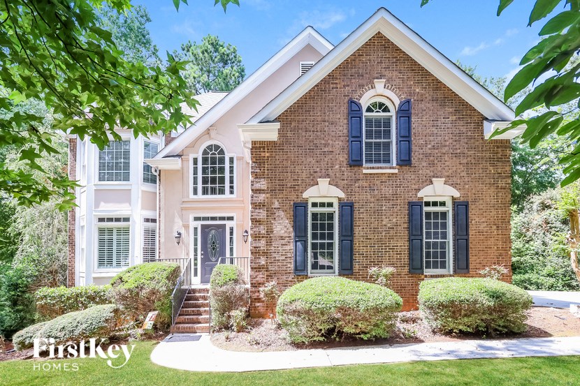 a brick house with blue shutters and a white front door
