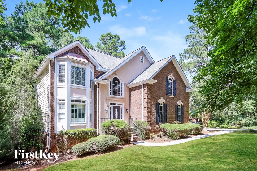 a house with a lawn and trees in front of it