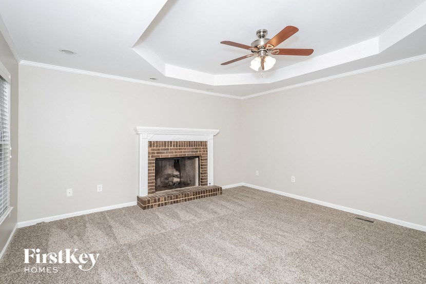 the living room with fireplace and ceiling fan