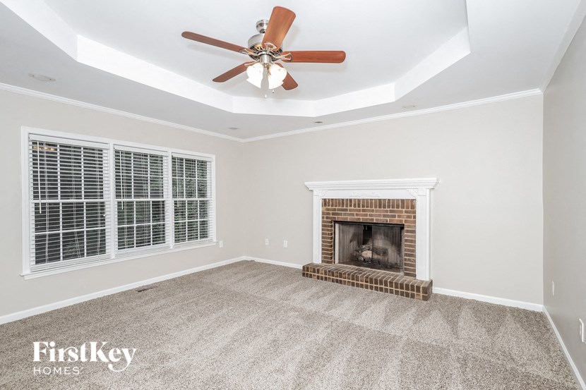 a living room with a fireplace and a ceiling fan