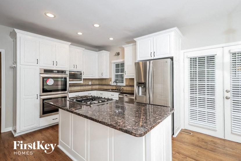 a kitchen with white cabinets and a granite counter top