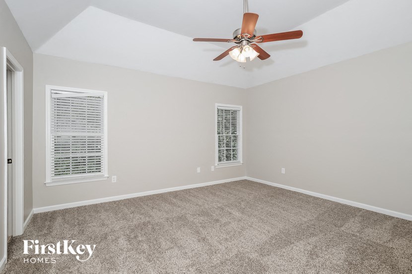 the living room of an empty house with a ceiling fan