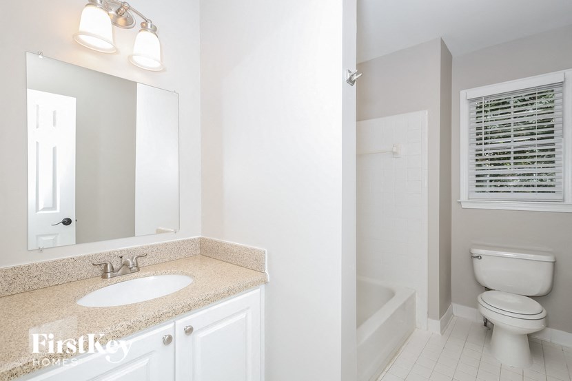 a white bathroom with a white toilet and a sink
