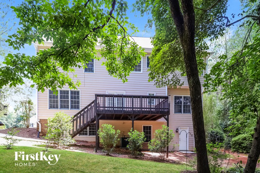 a house with a deck and a tree in front of it