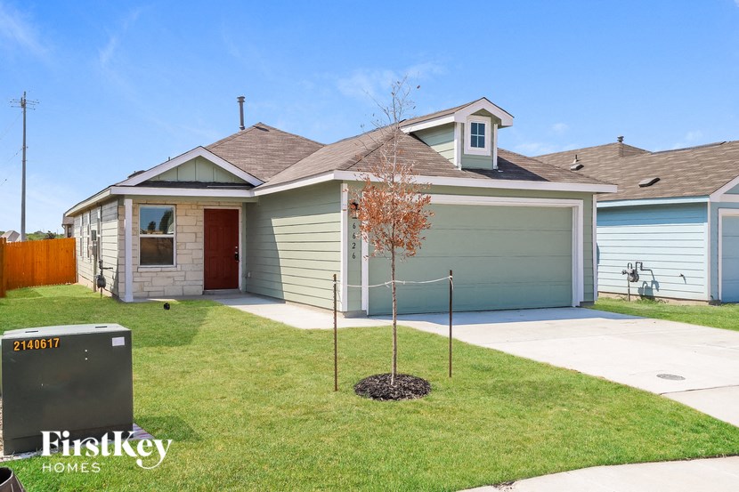 a house with a lawn and a tree in front of it