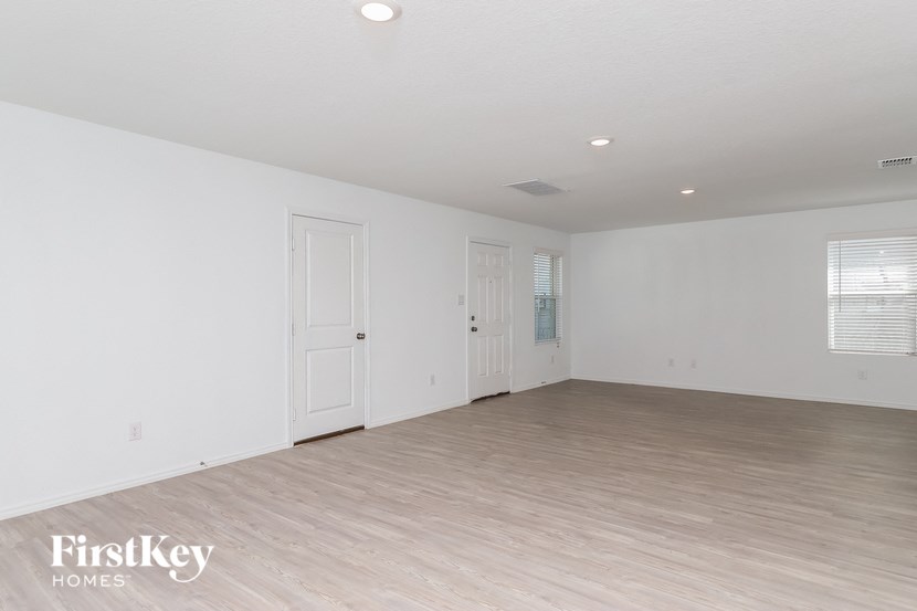 an empty living room with white walls and wood flooring