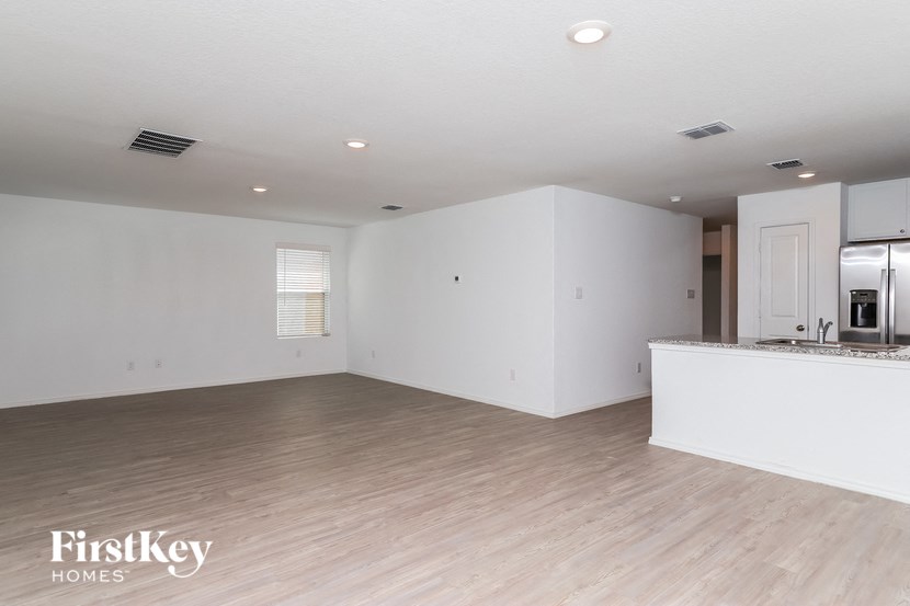 an empty kitchen and living room with white walls and wood floors