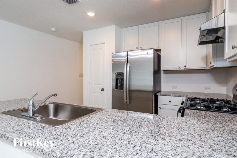 a kitchen with a sink and a stainless steel refrigerator