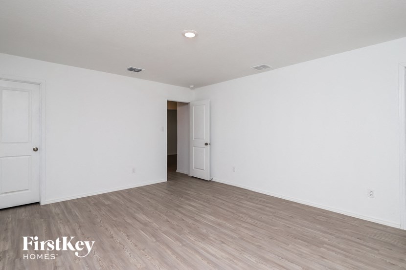 an empty living room with white walls and wood flooring