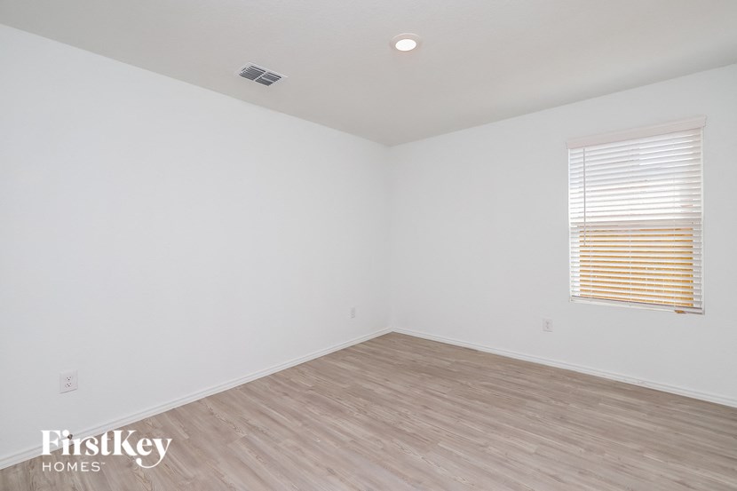 the living room of a home with wood flooring and a window