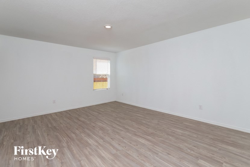 an empty living room with white walls and wood floors