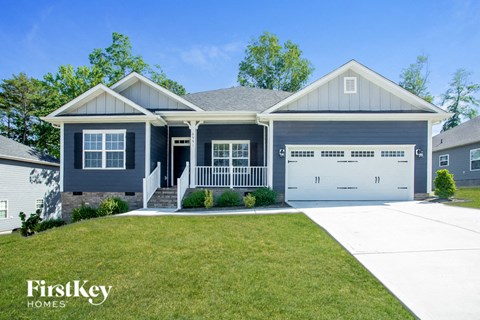 a blue house with a lawn and a white garage door