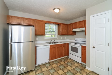 a kitchen with white appliances and wooden cabinets