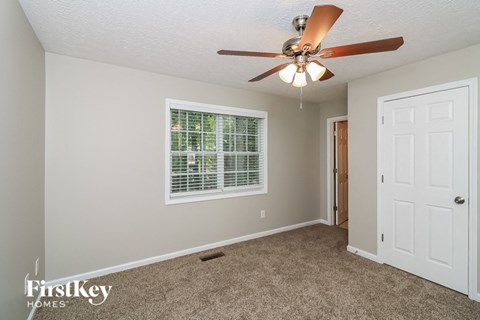 a bedroom with a ceiling fan and a white door