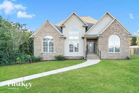 a home with a lawn and a sidewalk in front of it