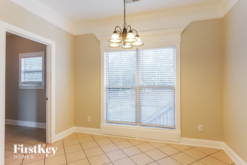 a dining room with a large window and a chandelier