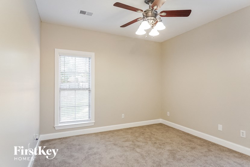a bedroom with a ceiling fan and a window