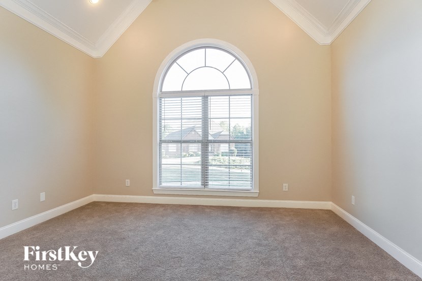 an empty living room with an arched window
