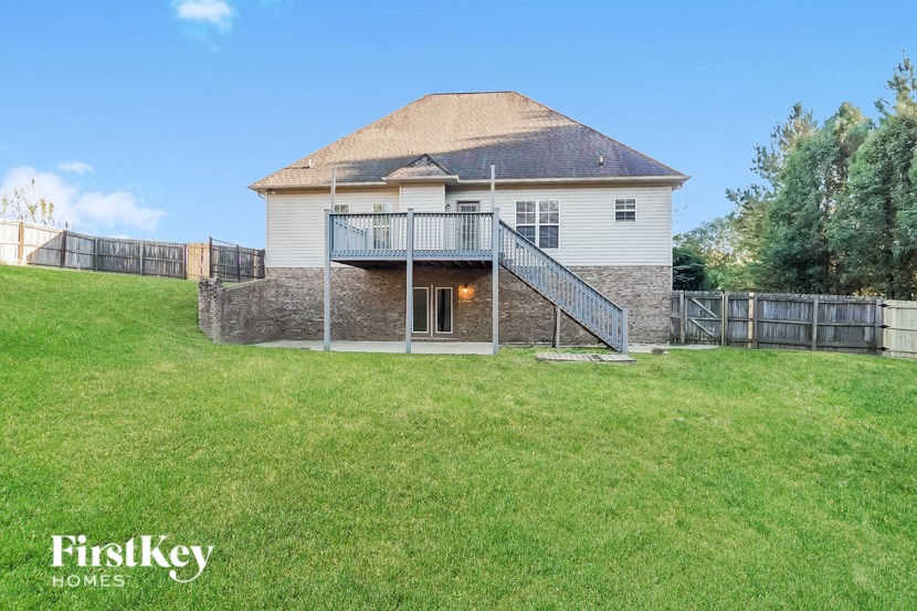 the back of a house with a yard and a fence