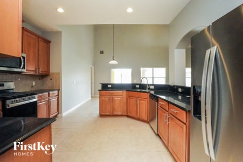 A kitchen with wooden cabinets and a stainless steel refrigerator.