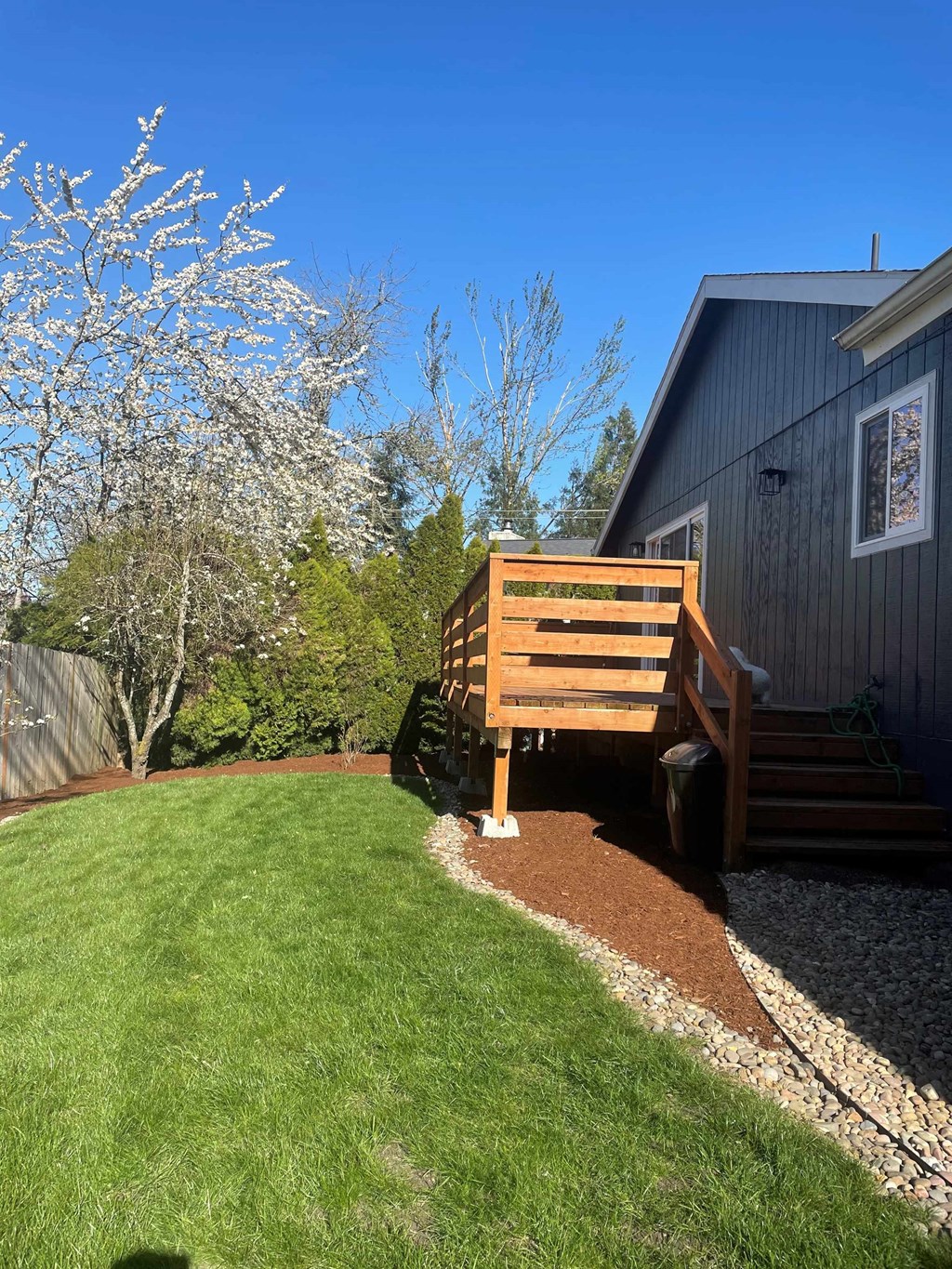 a backyard with a wooden bench in front of a house