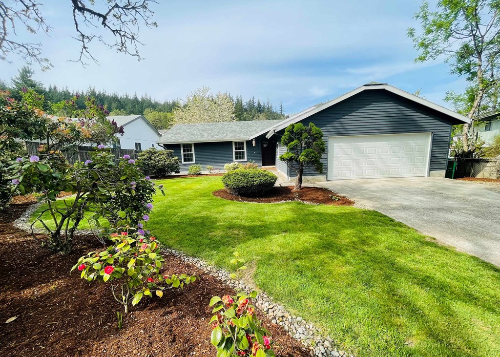a blue house with a yard and a garage