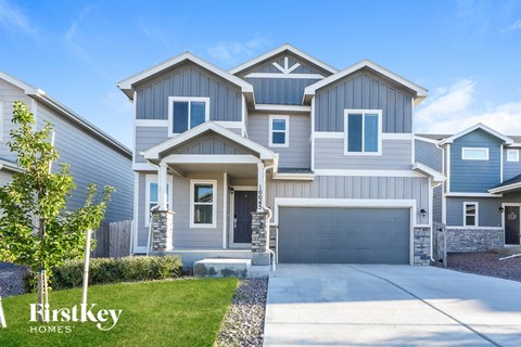 A row of houses with the first one being a two story house with a garage.