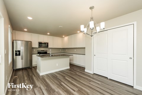 A kitchen with wooden floors and white cabinets.