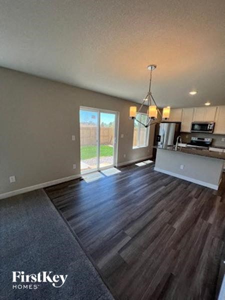 A kitchen area with a dining table and chairs.