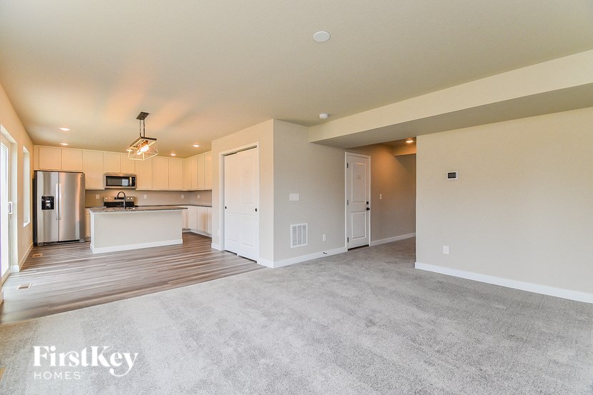 the living room and kitchen of an empty house