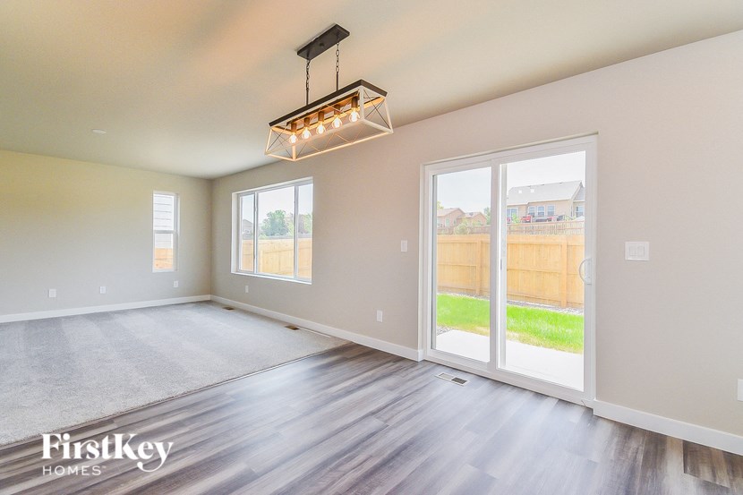 the living room of a new home with wood flooring and a large window