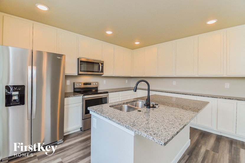 a kitchen with white cabinets and a granite counter top