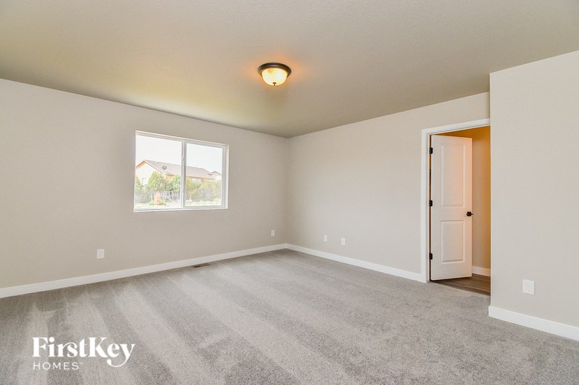 the living room of an empty house with carpet and a window